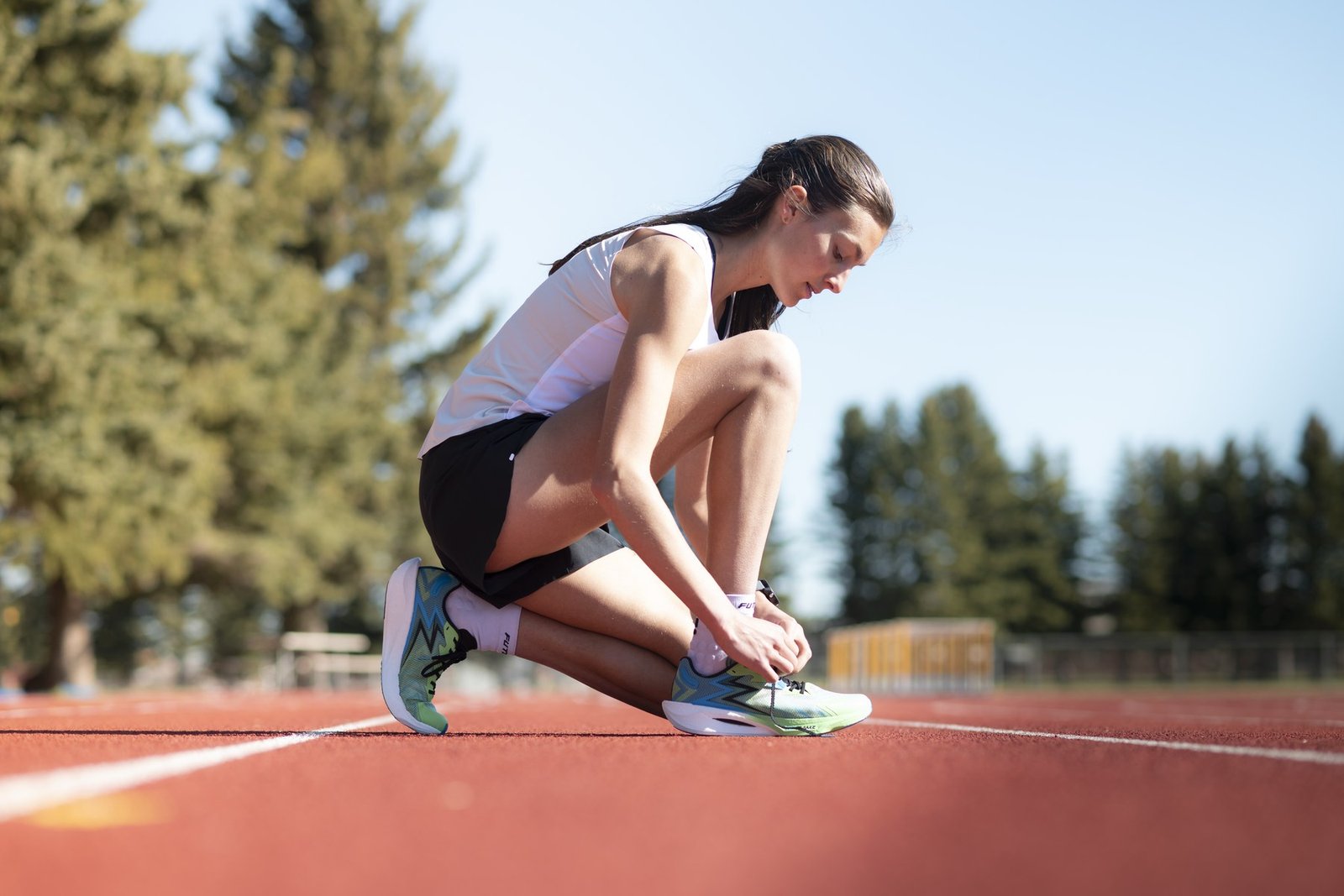 Athlete lacing up on the track