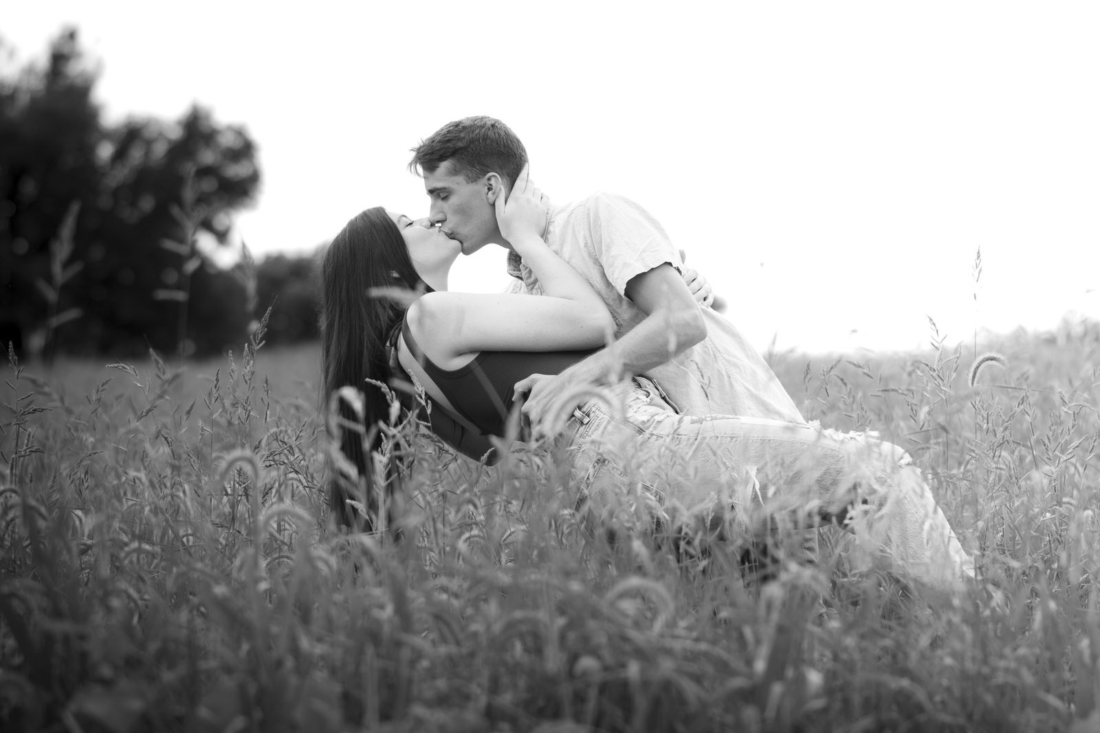 Couple kissing in field black and white